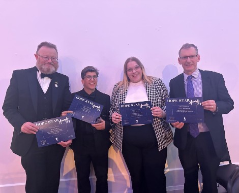 Two males and two females holding certificates.